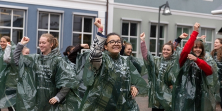 Unge mennesker har regntøj på og jubler 