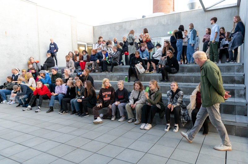 Unge mennesker sidder på en trappe udenfor