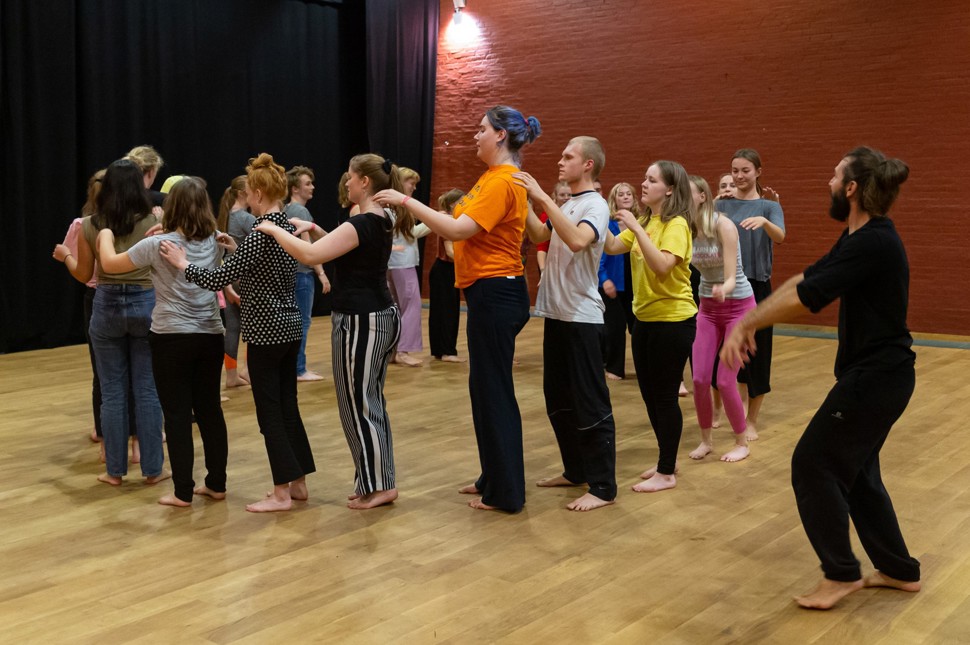 Unge mennesker danser i rundkreds