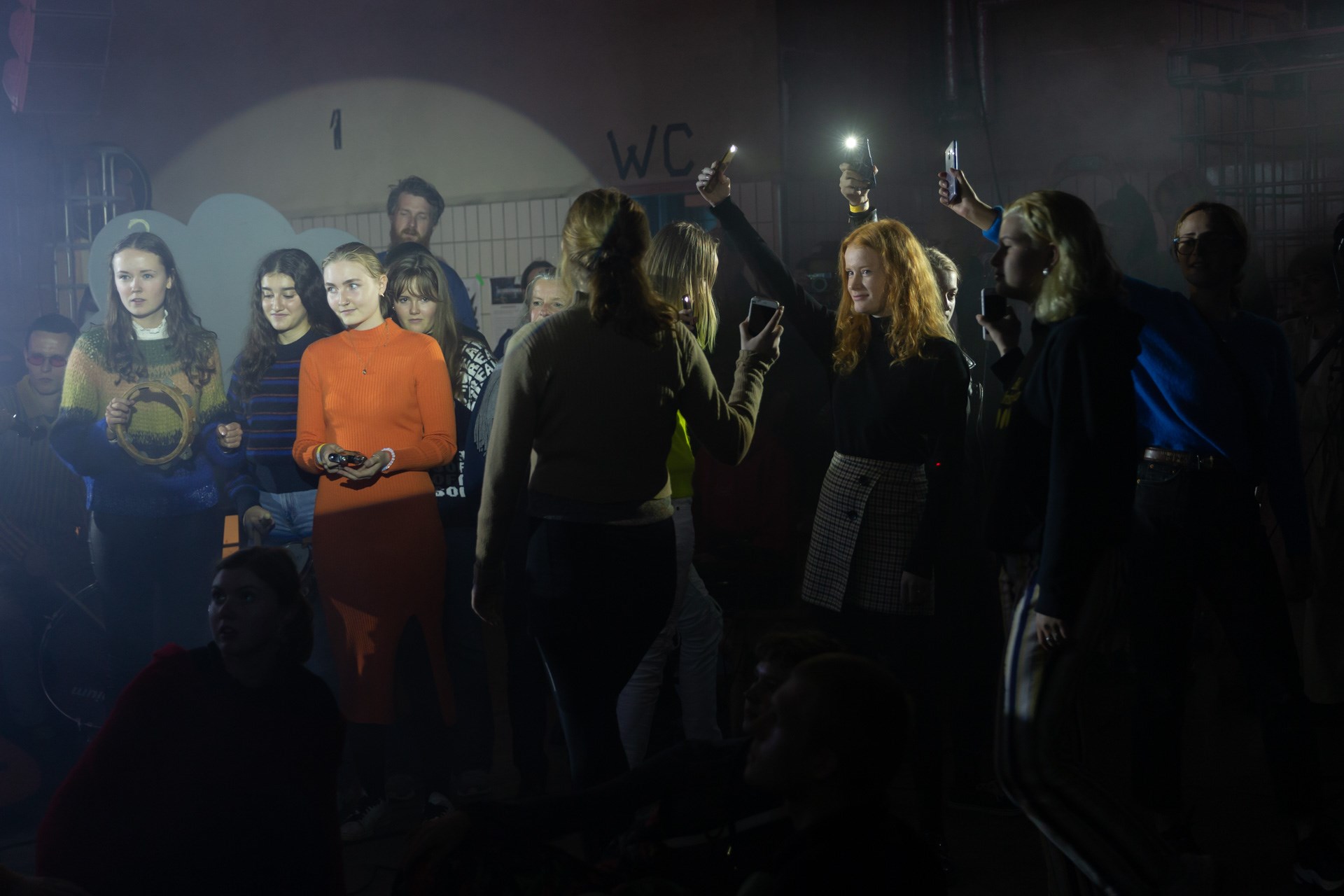 Unge mennesker lyser med deres telefoner 