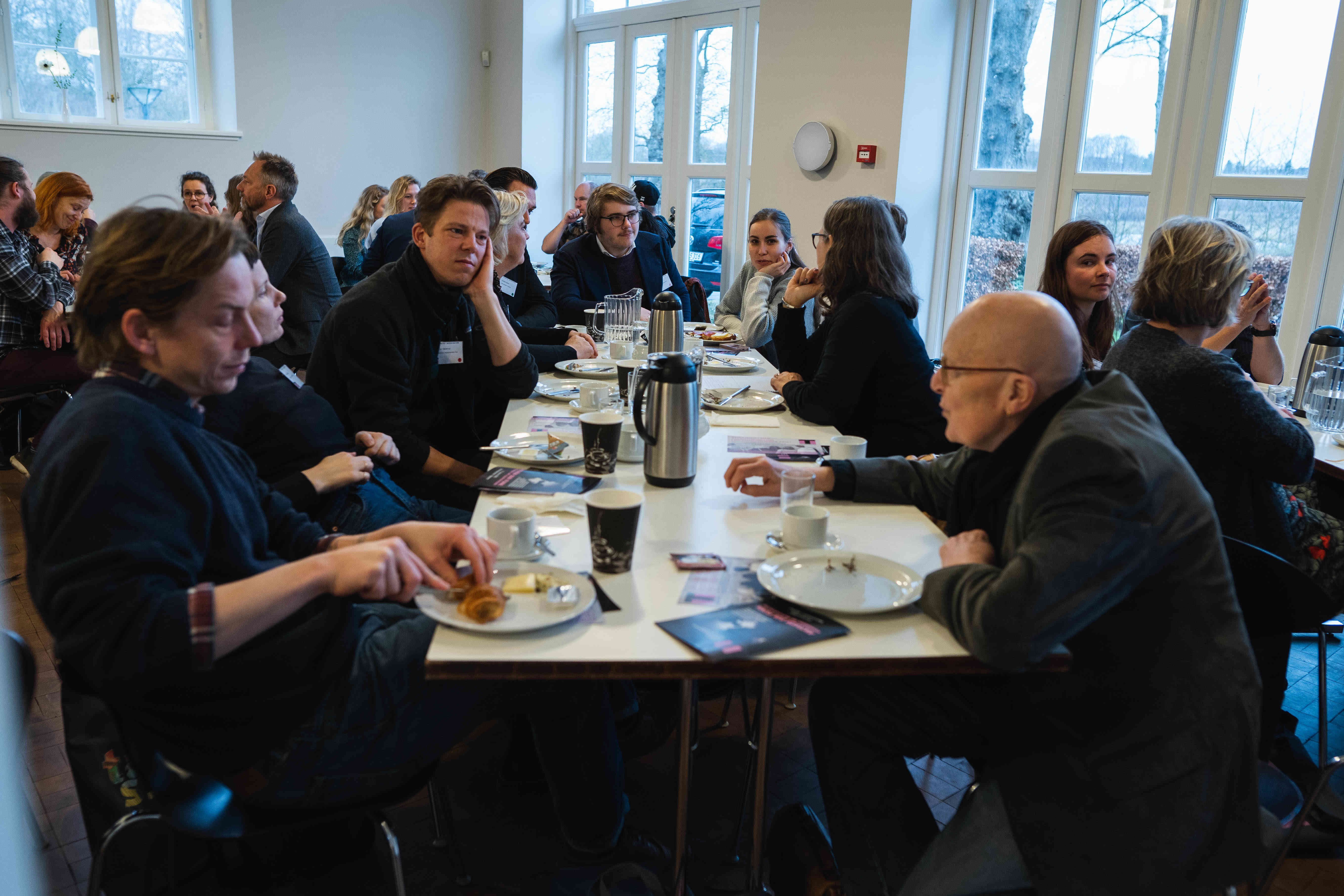 Voksne mennesker sidder og spiser 