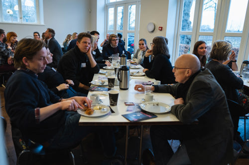 Voksne mennesker sidder og spiser 