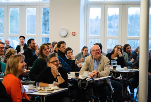Voksne mennesker sidder og smiler
