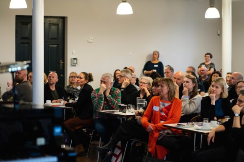 Voksne mennesker sidder og lytter til oplæg